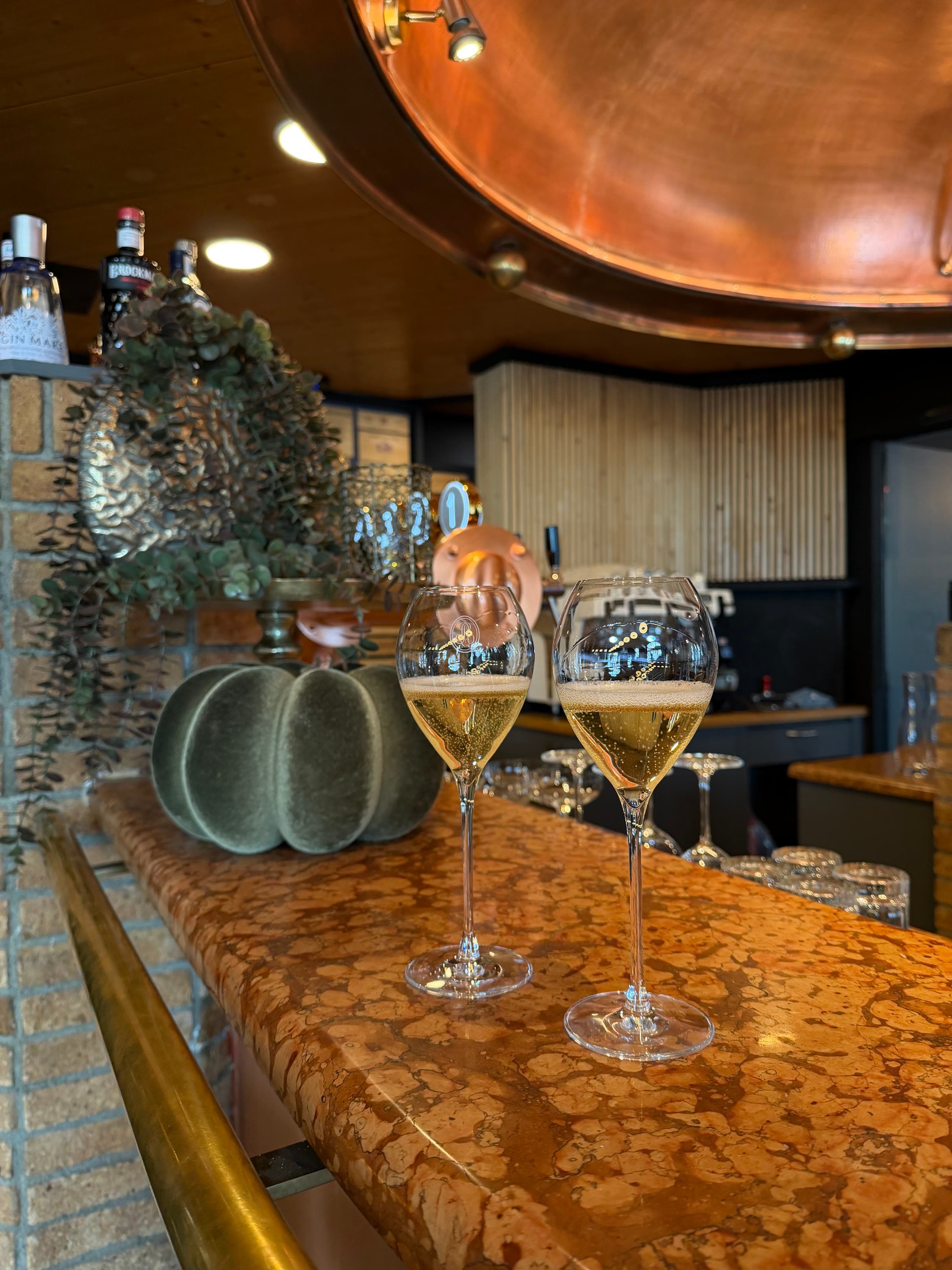 Two glasses of champagne on the copper bar top