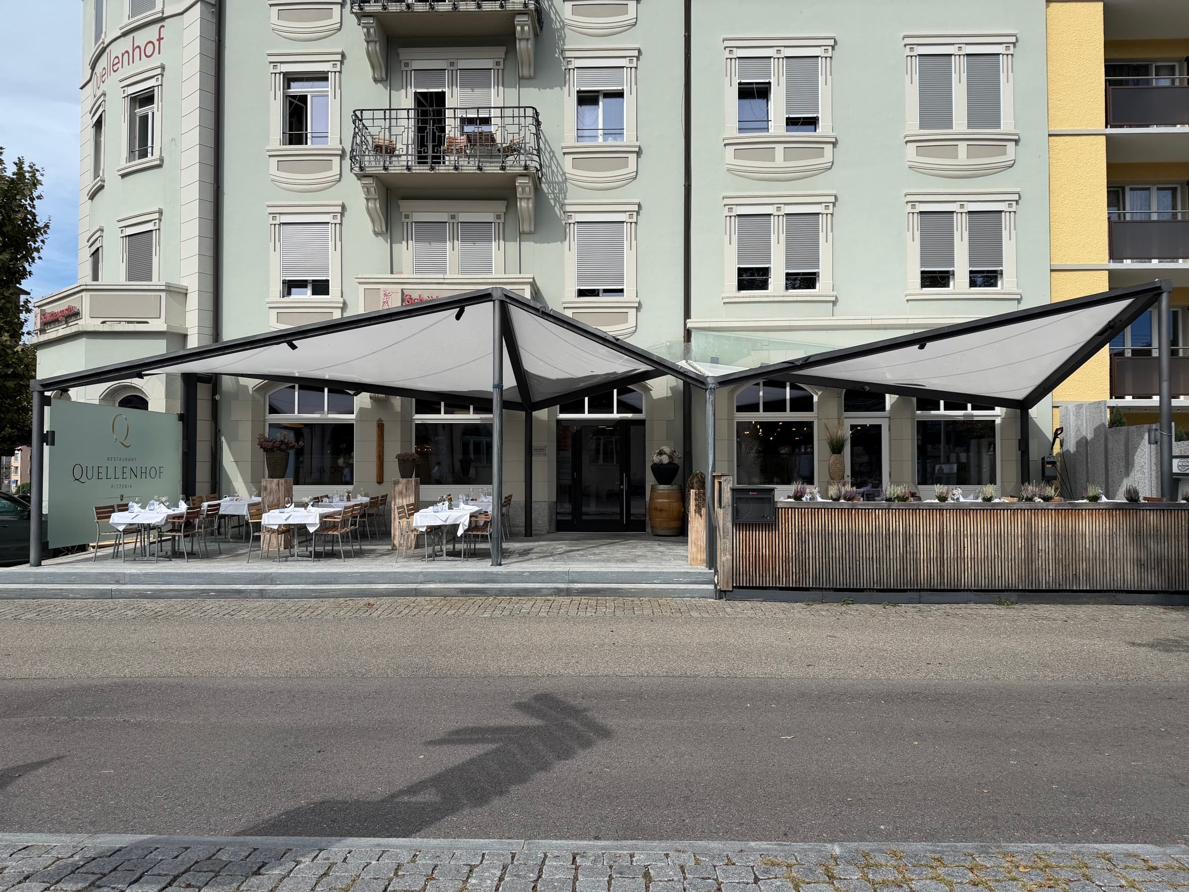 The house from the street, both awnings out over the terrace