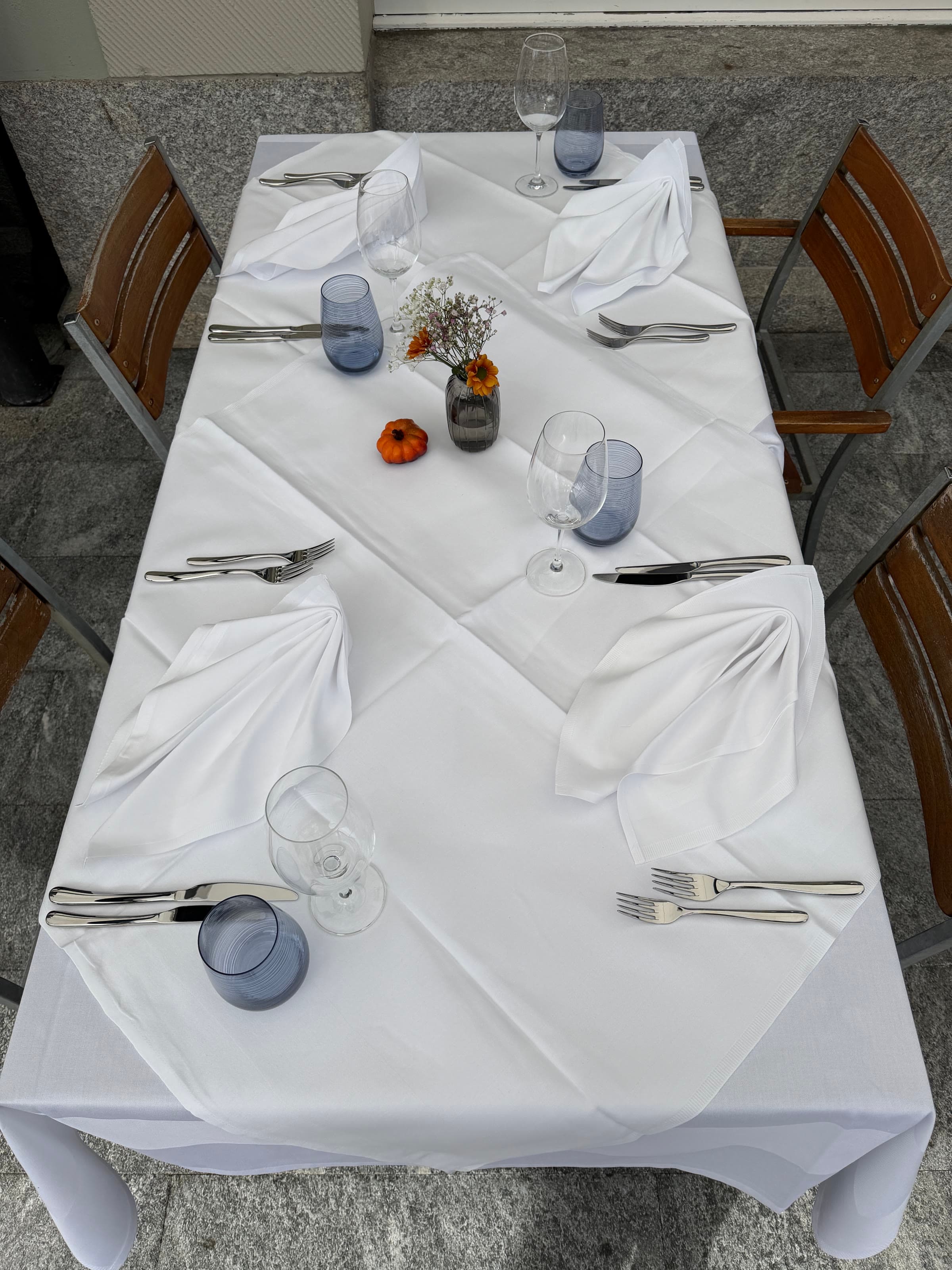 A long table laid, seen from above, linen and folded napkins