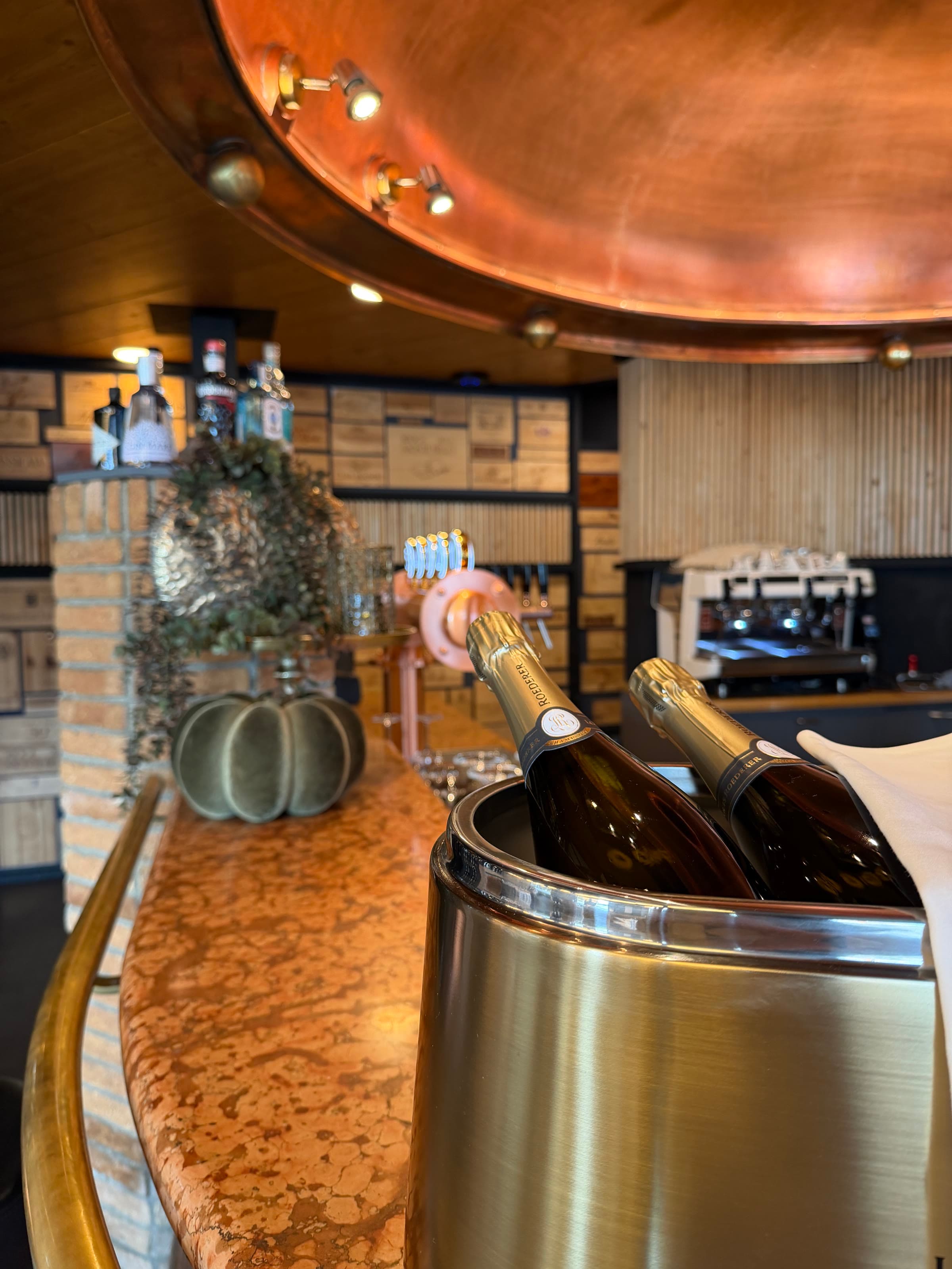 Zwei Flaschen im Kühler auf der Kupfertheke der Bar